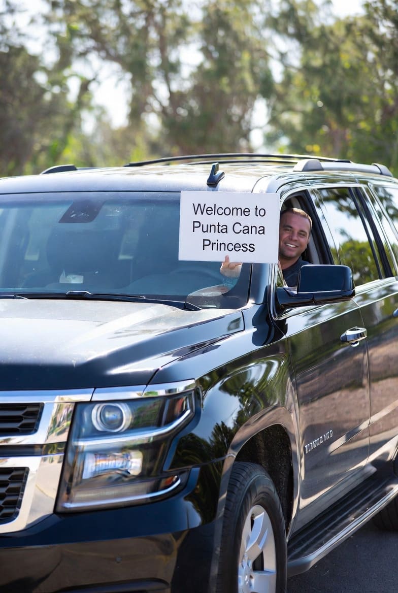 Black Chevrolet Suburban with driver holding Welcome to Punta Cana Princess sign for private airport transfer from PUJ